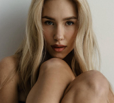 Квіткова у корсеті та ажурних колготках млосно попозувала з випнутим бюстом