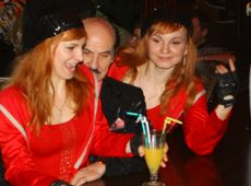 Чапкіс обіймається з молоденькими близнючками і тримає їх за колінки