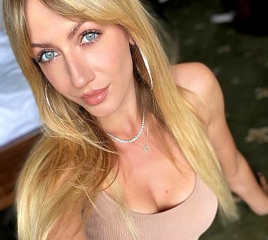 Млосна Нікітюк у купальнику вигнулася на тлі напівголого мужчини з пивом