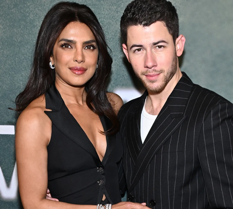 Пріянка Чопра у декольтованому топі та обтислій спідниці притулилася до чоловіка на бродвейському хіднику. Фото