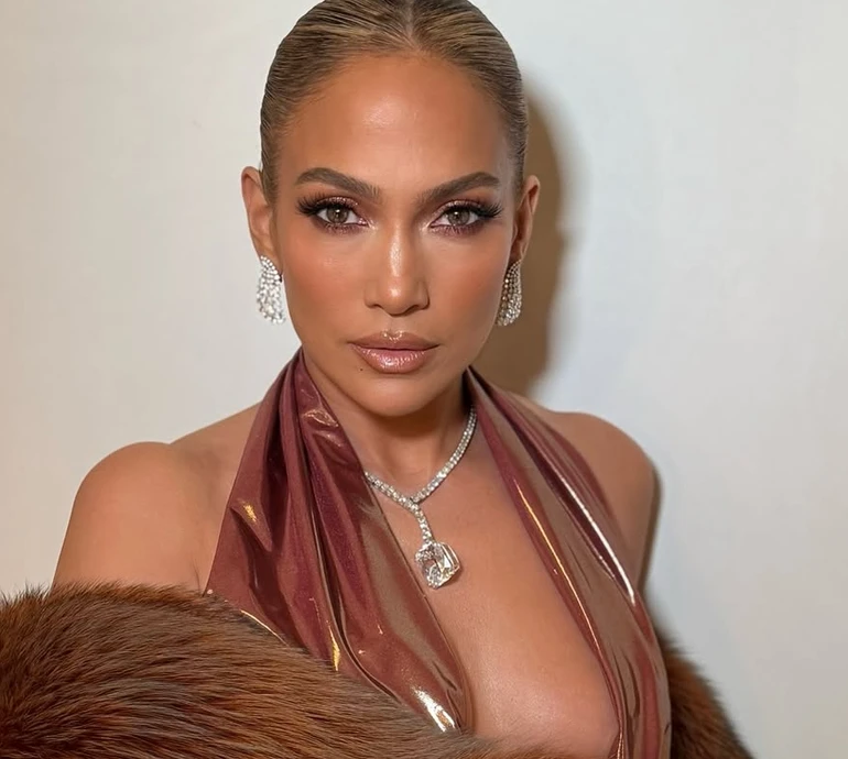 Гола спина та декольте до пупа: Лопес у блискучій сукні та шубі наробила звабних фото біля стіни