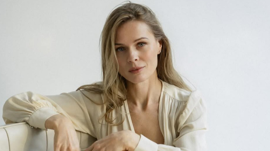 Фреймут у кремовій сукні посиділа босоніж на кріслі для ніжних фото