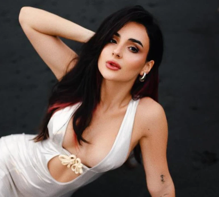 Трінчер знову перефарбувалася і показала, як у сукні з вирізом до пупа вигиналася на чорному пляжі