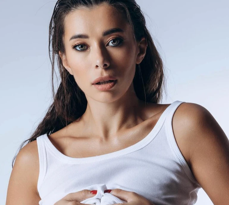 Неплях у боксерках та задраній майці блиснула голими грудьми, позуючи на стільцях