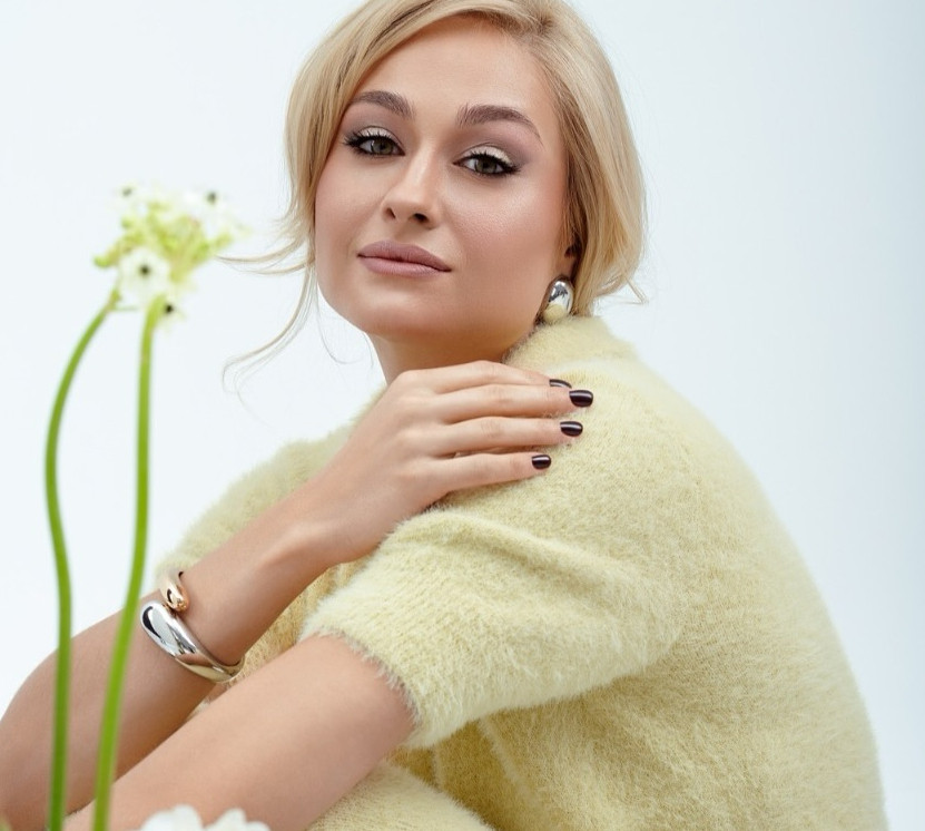 Цимбалару у гіпюрових колготках і прозорій сорочці посвітила спіднім у звабній позі серед квітів. Фото