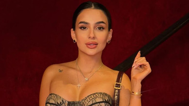 Трінчер у хижому луці з голими плечима поманіжилася на тлі паризьких краєвидів