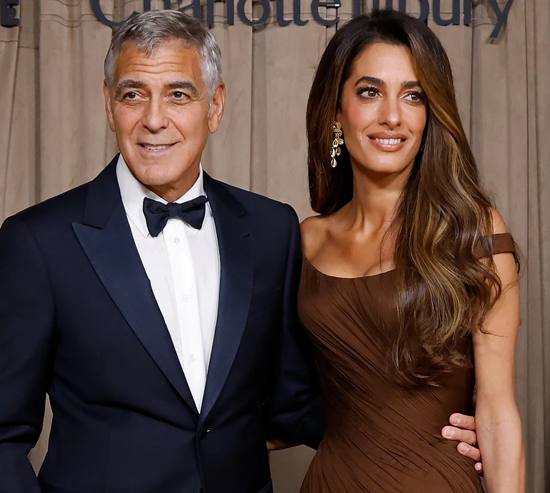 Клуні в темно-синьому смокінгу з дружиною в шоколадній сукні та з бронзовим мейком провели благодійну виставку у Лондоні