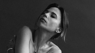 Карпа топлес прикрила груди руками на чорно-білих студійних фото