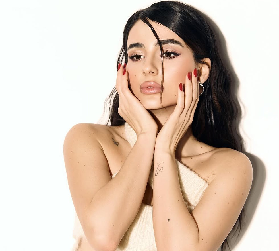 Панчохи, спіднє і комбінезон з розрізами: Трінчер із голими стегнами спокушала таємничого чоловіка у новому кліпі