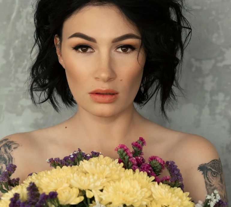 Приходько з букетом квітів на грудях взялася піднімати весняний настрій