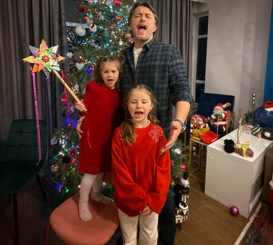 Притула з двома дочками заспівав колядку біля ялинки на різдвяному відео