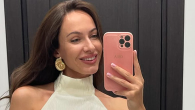 Горняк у бікіні граційно попозувала на камінні коло моря. Фото