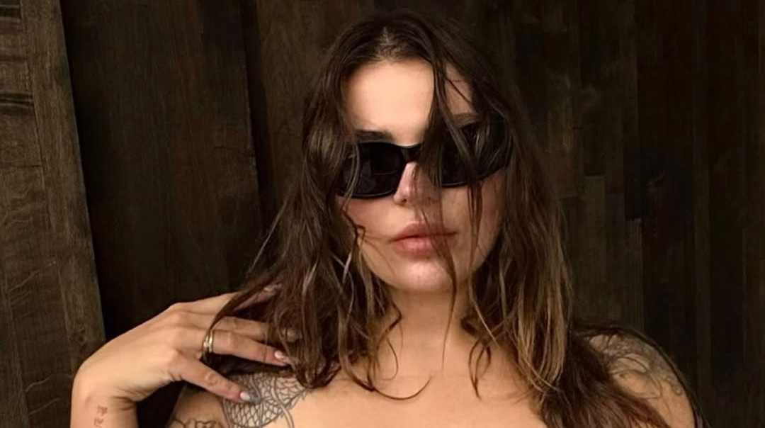 Заріцька у панчохах прикрила оголені принади журналом на спекотних фото