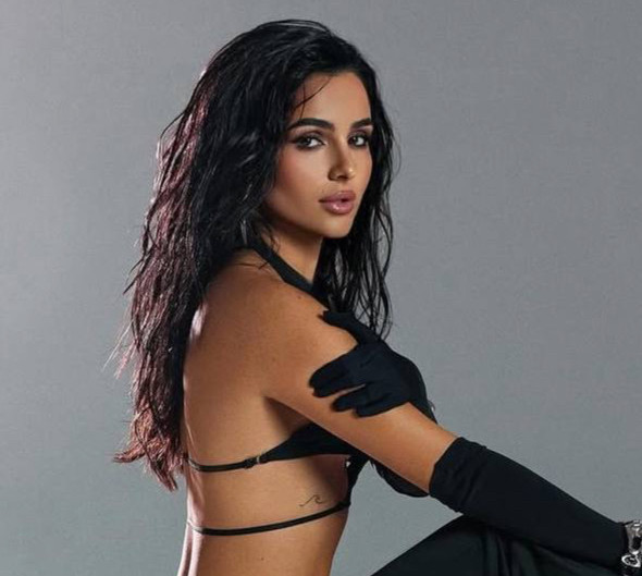 Трінчер у крихітному топі вигадливого фасону повигиналася на байку для гарячих фото