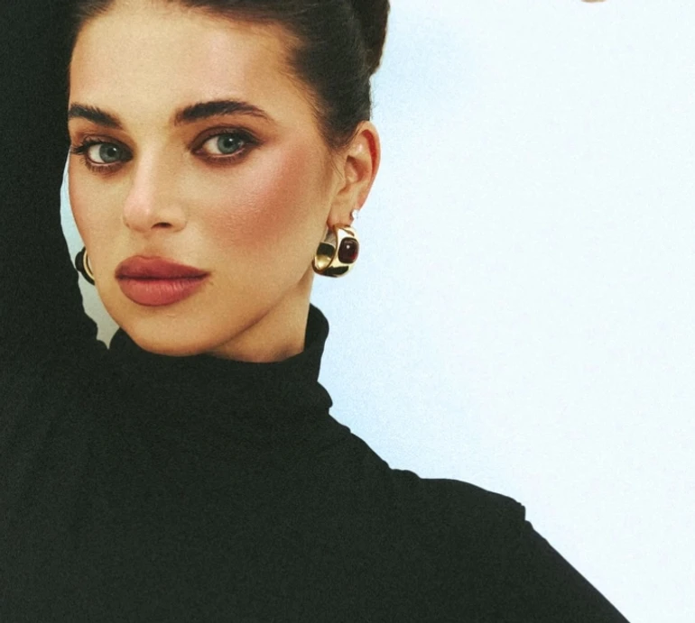 Дружина Усика в комбінезоні з оголеною спиною попозувала на підлозі зі стільцем. Фото