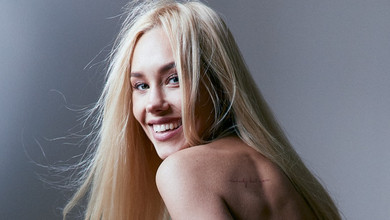 Квіткова у спортивних штанях прикрила голі груди руками для фото