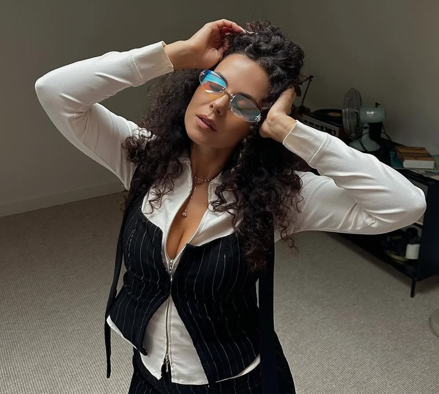 Каменських у смугастому міні грайливо присіла на комод, щоб похизуватися стегнами. Фото