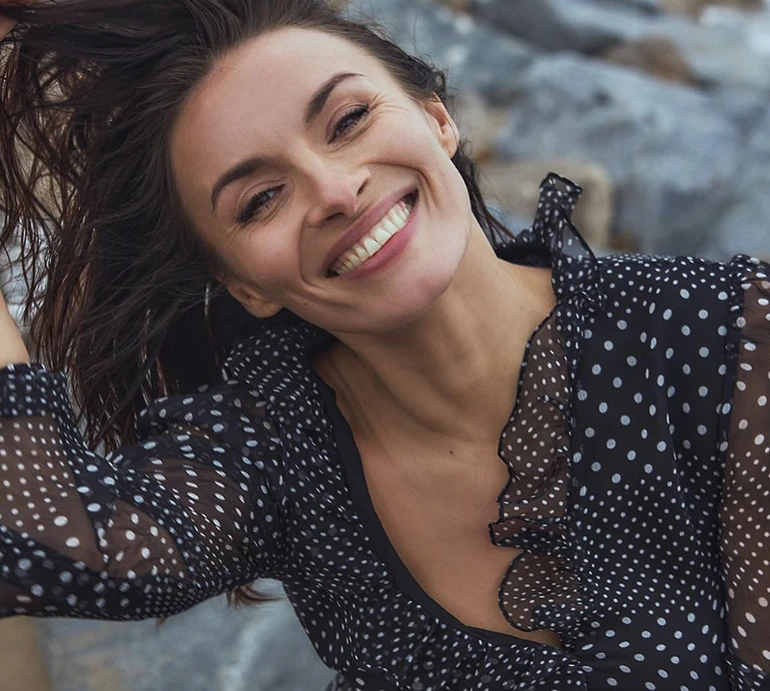 Мейхер у в'язаному кроптопі оголила живіт на тлі природи. Фото