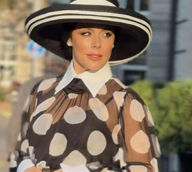 Онуфрійчук у крупних горохах та крислатому капелюсі притулилася до стовпа в елегантній зйомці