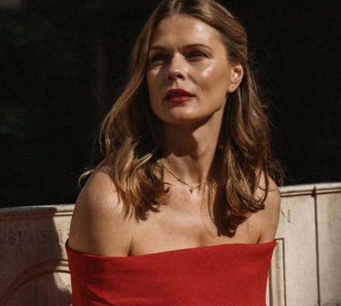 Витончена Фреймут у червоній сукні з голими плечима попозувала на кам'яній лаві. Фото