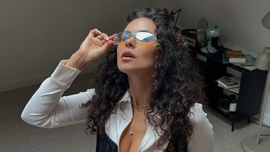 Каменських у смугастому міні грайливо присіла на комод, щоб похизуватися стегнами. Фото