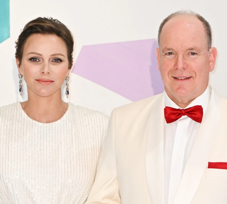 Княгиня Шарлін у вишуканій асиметрії увінчала чоловіка картатою панамкою. Фото