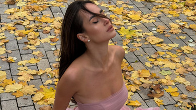 Парфільєва у розкішному платті кольору туманної ружі померзла в осінньому парку з мегафоном. Фото