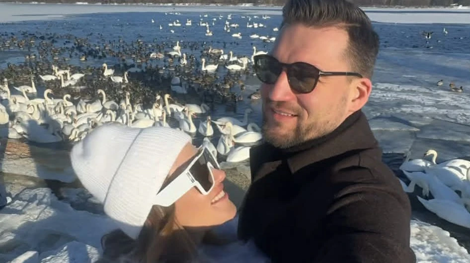 Лайт режим: Денисенко у ромпері та шубі з лами притулилася до коханого на тлі зграї лебедів