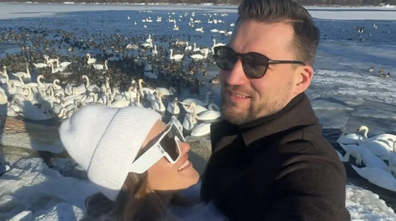 Лайт режим: Денисенко у ромпері та шубі з лами притулилася до коханого на тлі зграї лебедів