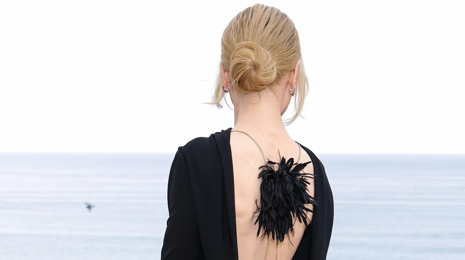 Вайб 90-х і волохата прикраса: Кідман на показі Chanel у Біарріці оголила спину в маленькій чорній сукні