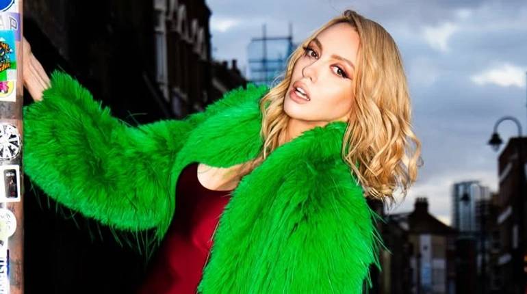 Полякова в боді та кольоровому хутрі пораділа пришестю весни коло стовпа. Фото