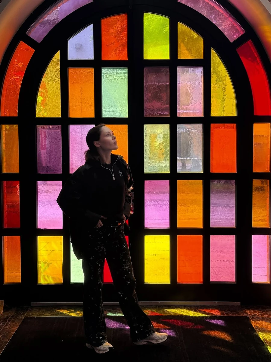 Юлія Саніна у стильних джинсах попозувала біля кольорового вікна