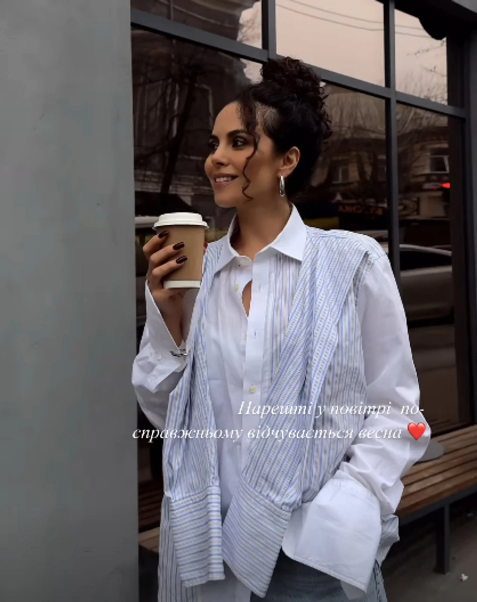 Каменських у модній сорочці та з напоєм попозувала на вулиці