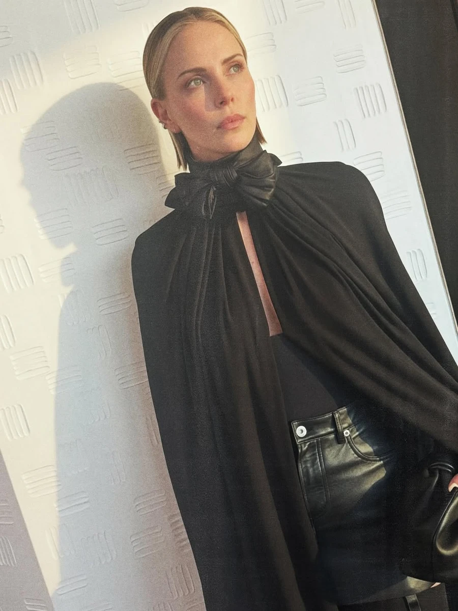 Шарліз Терон зі стильною накидкою та в міні попозувала на показі мод