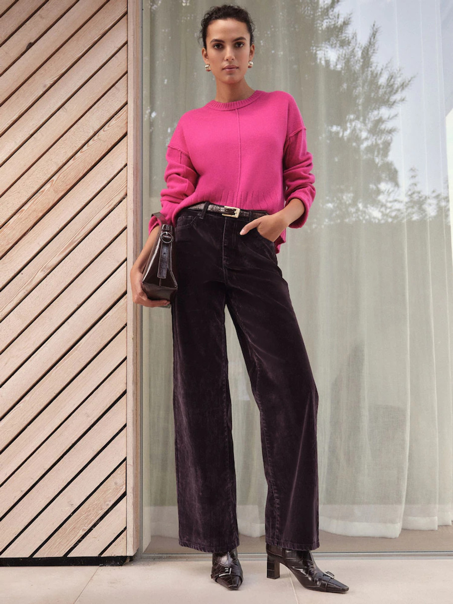 Дівчина в рожевому светрі і коричневих вельветових штанах