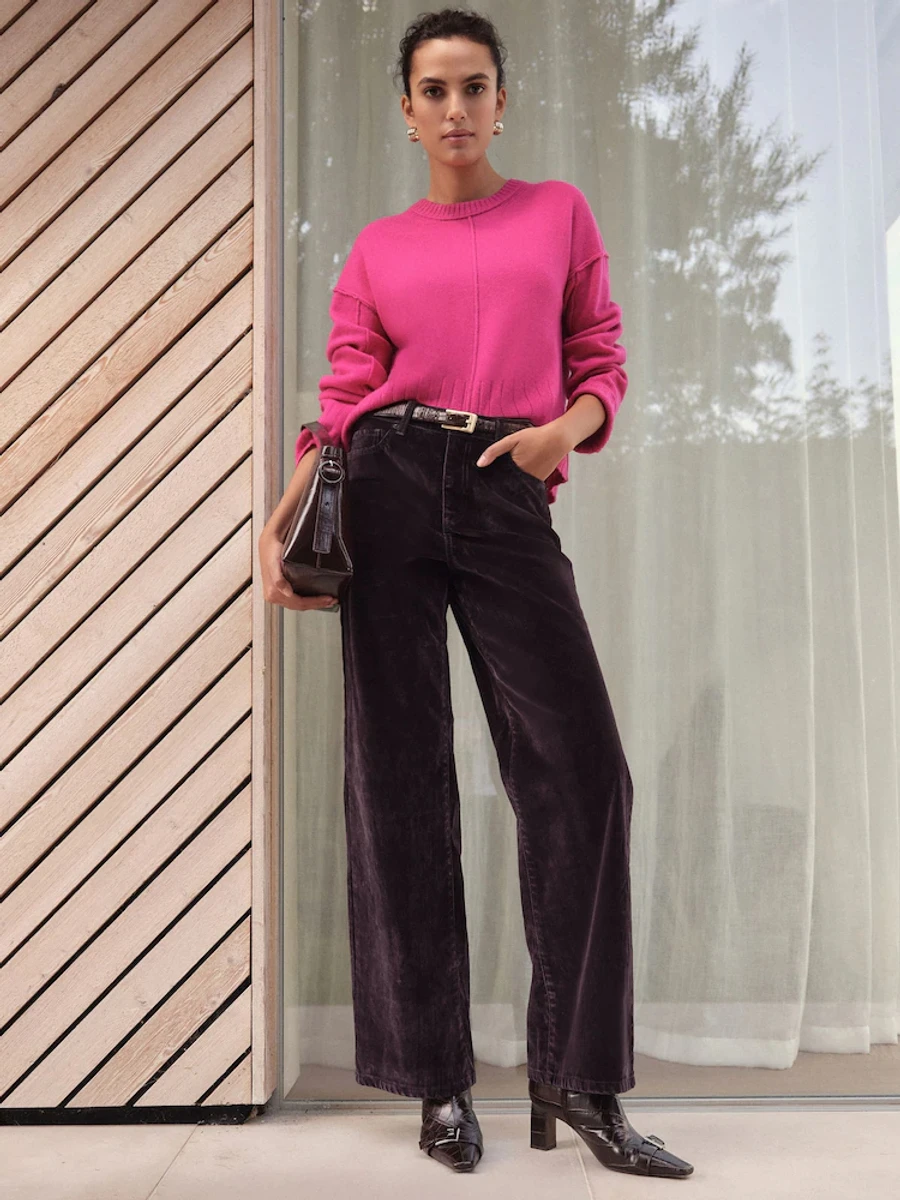 Дівчина в рожевому светрі і коричневих вельветових штанах