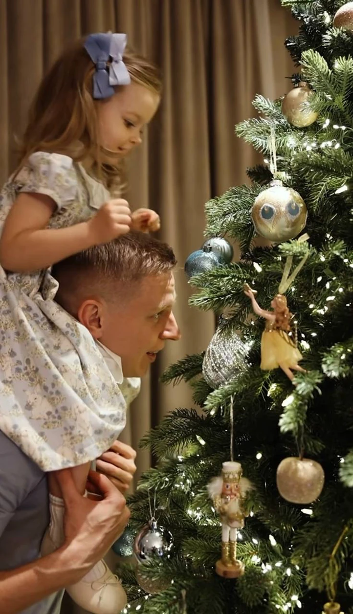 Олександр зі старшою донькою прикрашають ялинку