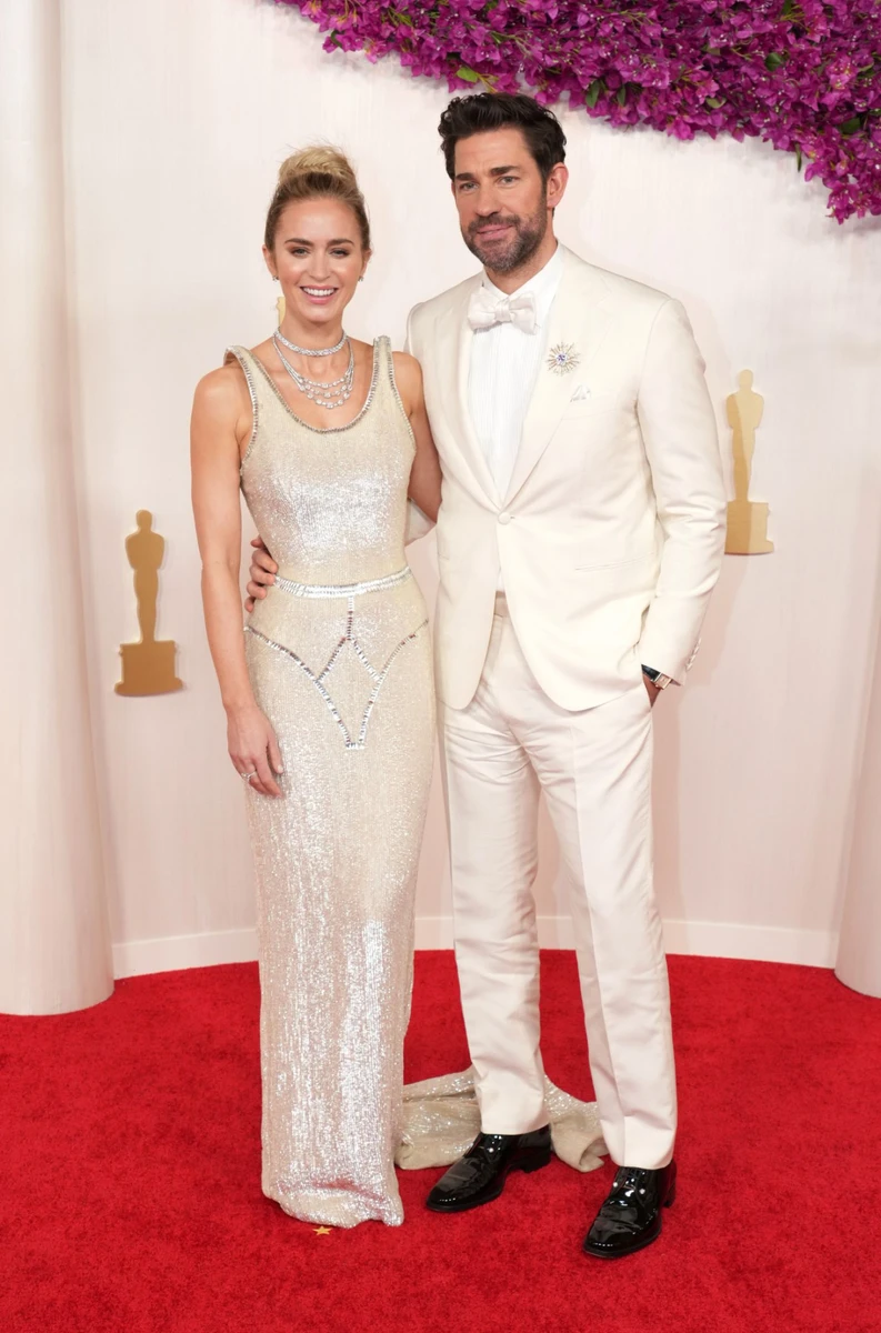 Номінантка на премію у категорії Найкраща актриса другого плану за роль у Оппенгеймері Емілі Блант обрала блискучу сукню від Schiaparelli Spring 2024 Haute Couture з прикрасами Tiffany & Co jewels. Чоловік актриси Джон Красінскі доповнив її образ костюмом у колір сукні