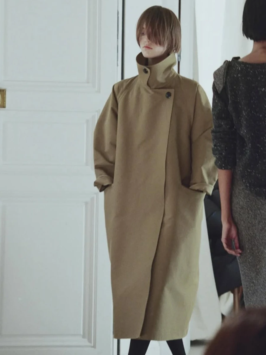 Дівчина у довгому пальті з високим коміром