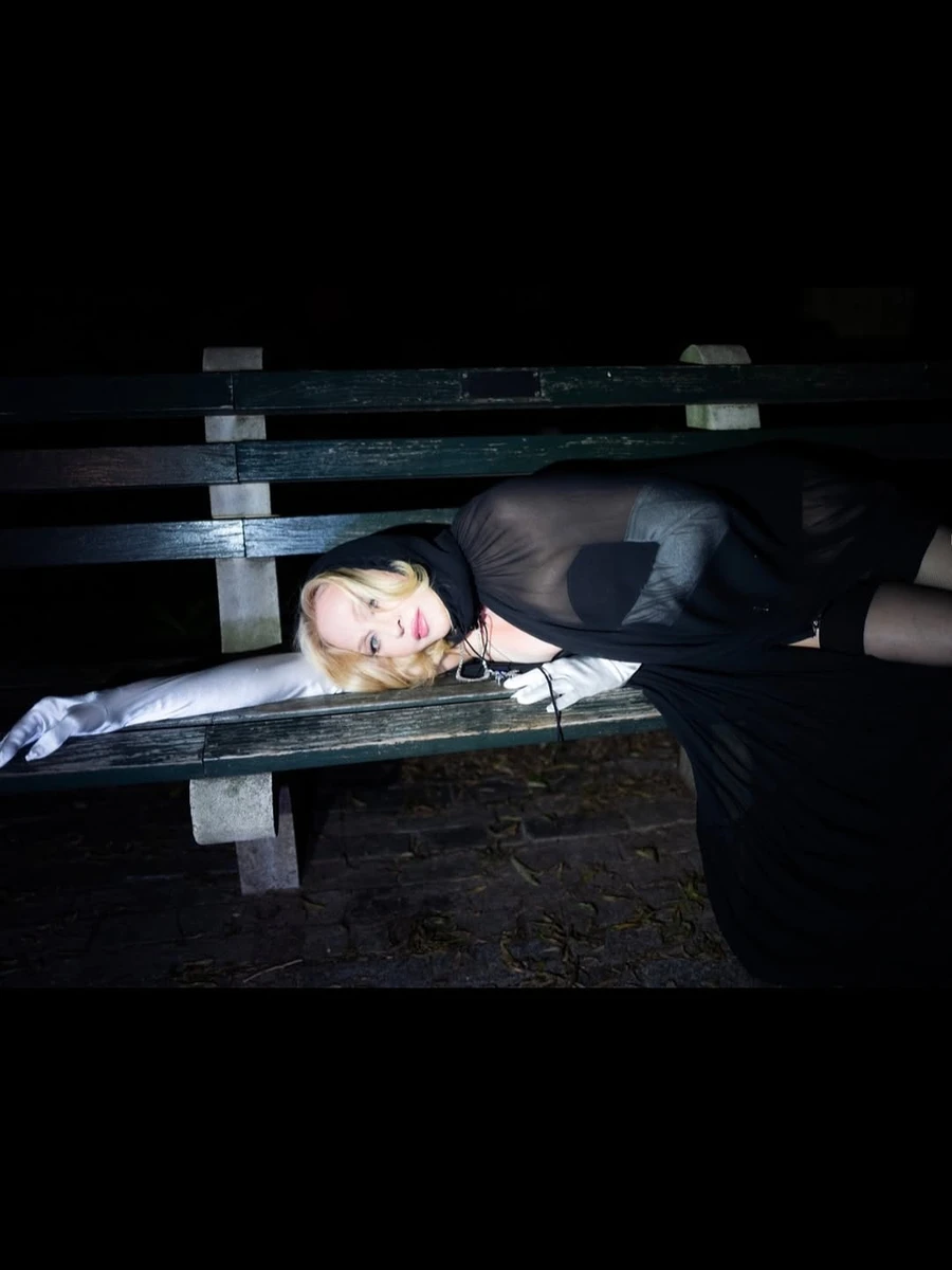 Мадонна у прозорій тканині лягла на лавку для фото