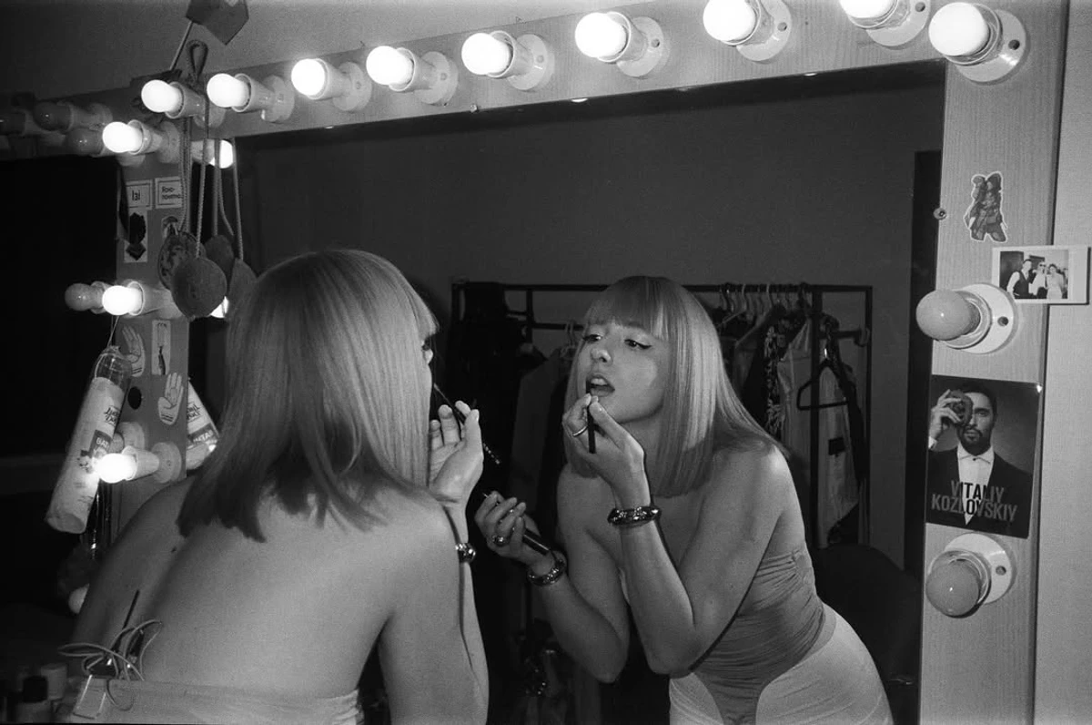 Грісана фарбується біля дзеркала