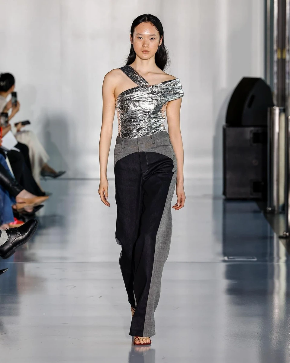 Модель у сріблястому топі на подіумі