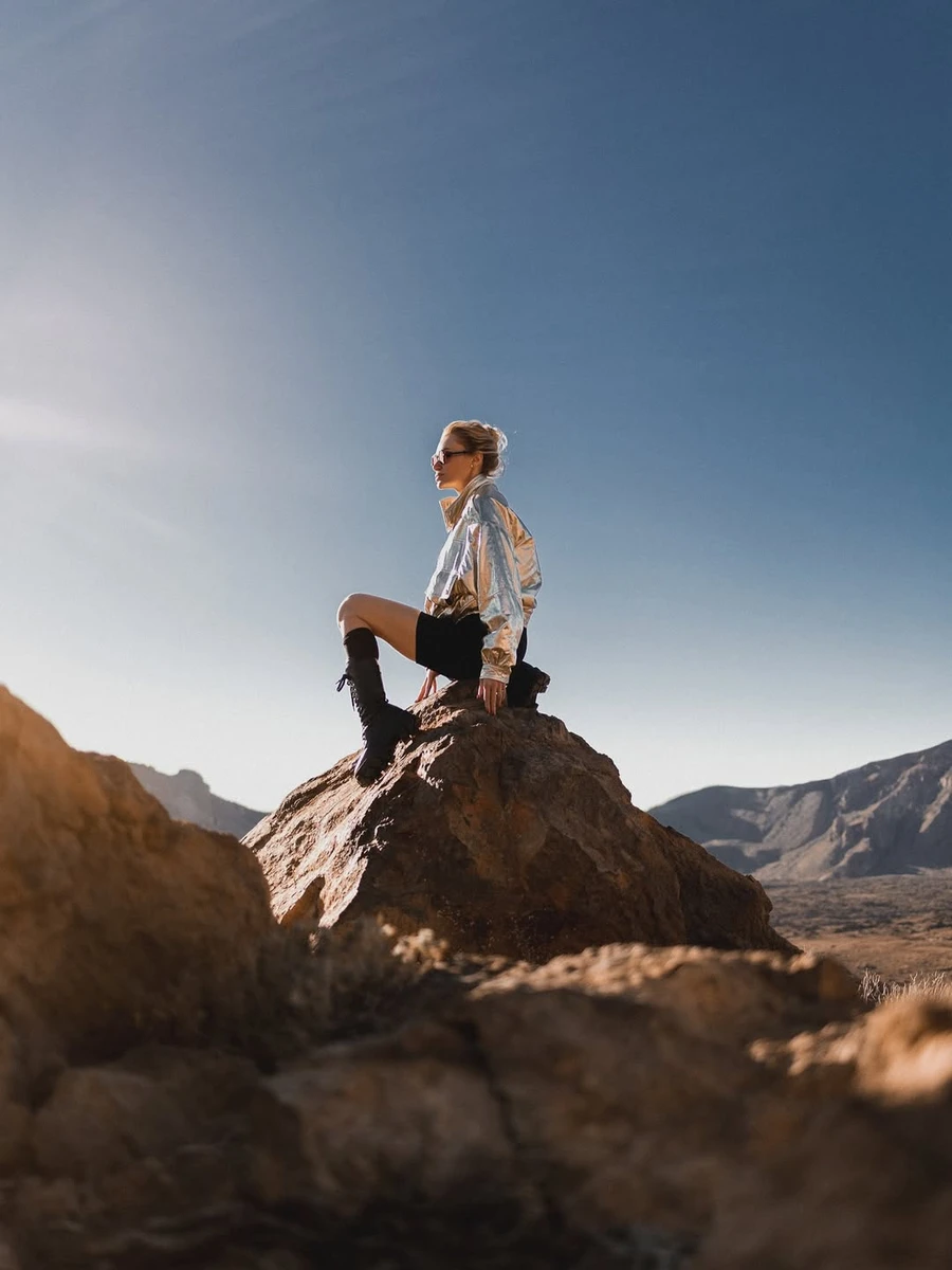 Слава Камінська в шортах розсілася на скелі, показуючи довгі ноги