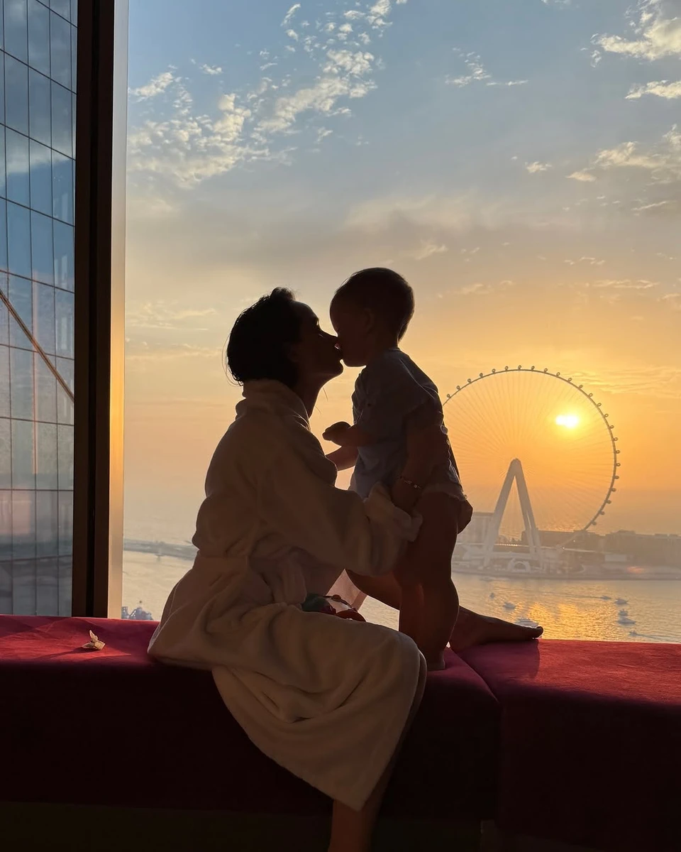 Таня Парфільєва з дитиною на тлі моря