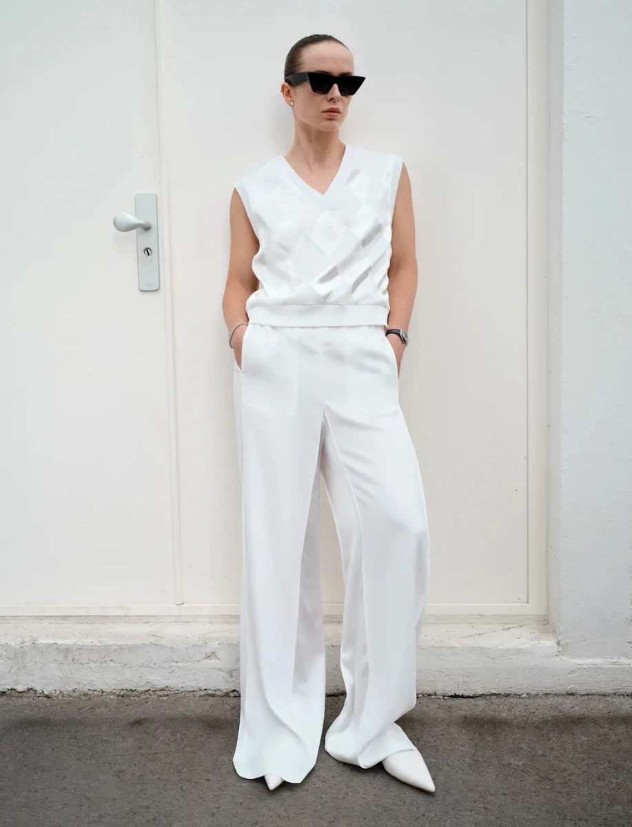 Еліна Світоліна у штанах і жилеті притулилася до стіни для реклами