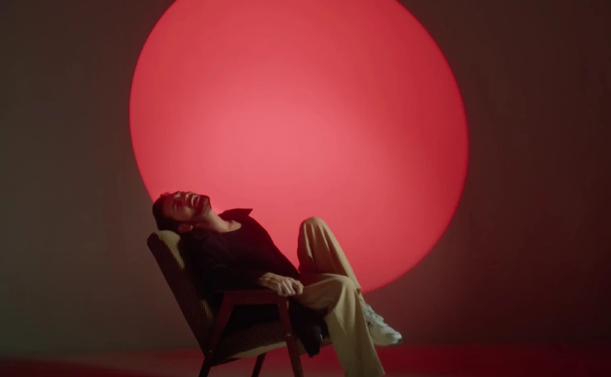 Артист у кліпі млосно танцює та вигинається на меблях