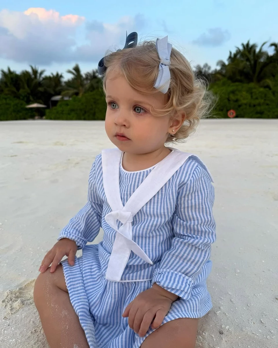 Молодша донька Зінченка сидить на пісочку