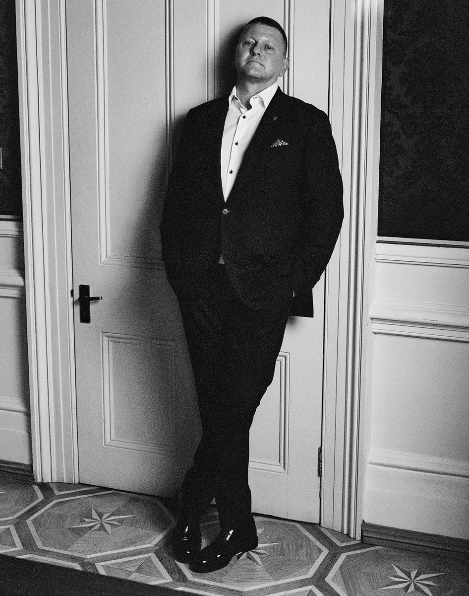 Валерій Залужний в стильному костюмі притулився до дверей для фото в глянці