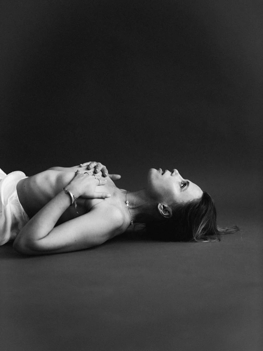 Ірена Карпа лежить з голими грудьми