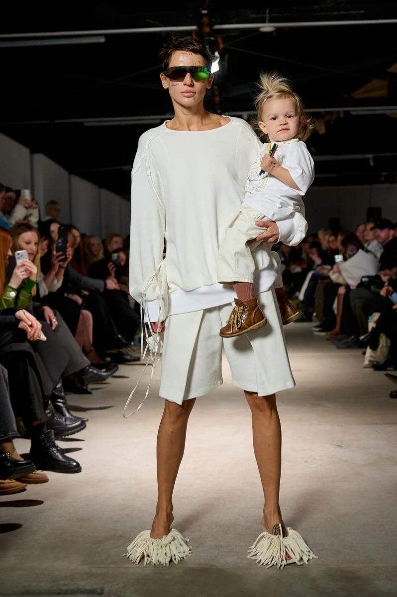 Модель з дитиною на руках на подіумі BOBKOVA